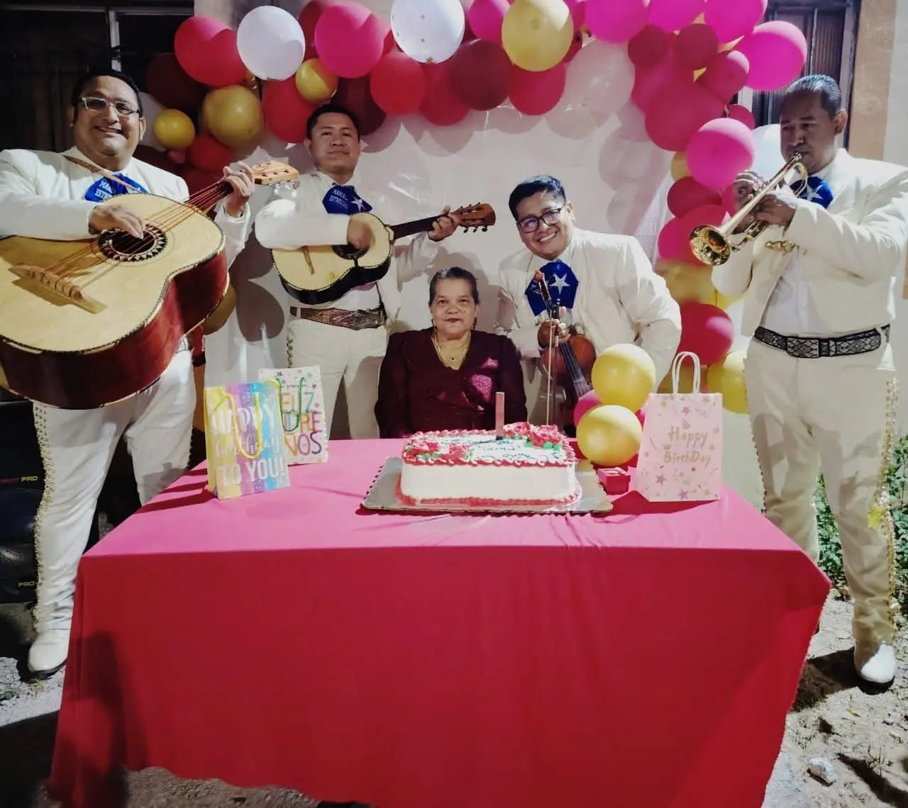 Mariachi Playense cantando Las Mañanitas junto a un pastel de cumpleaños